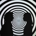 Silhouette of 2 People Standing in Front of Round White and Black Stripe Wall